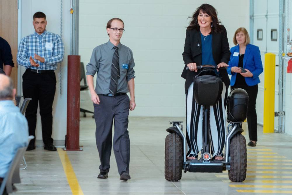 President Philomena Mantella riding on a Segway at the Engineering Design Project Preview